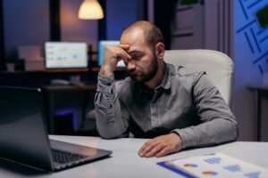Professional sitting at desk looking tired and contemplative about career change