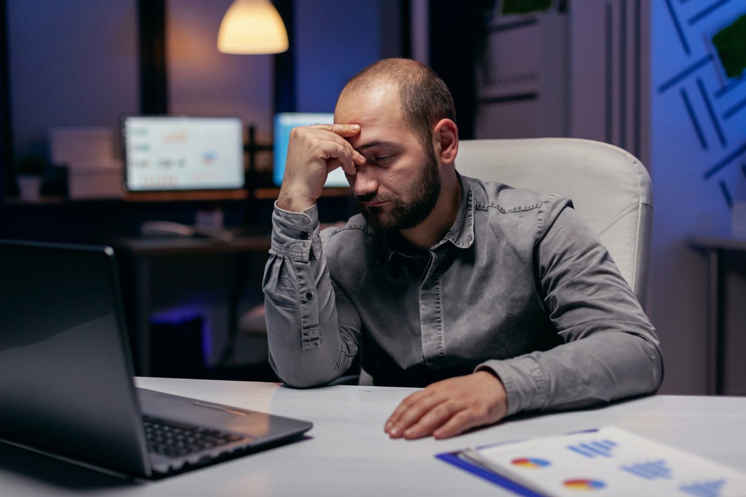 Professional sitting at desk looking tired and contemplative about career change