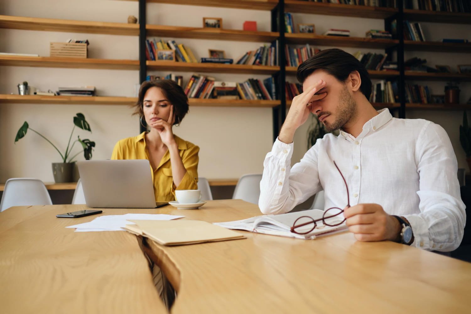 Job seeker in interview room looking nervous with interviewer taking notes
