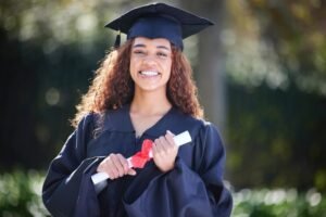 Student researching scholarships on laptop with graduation cap and dollar signs in background