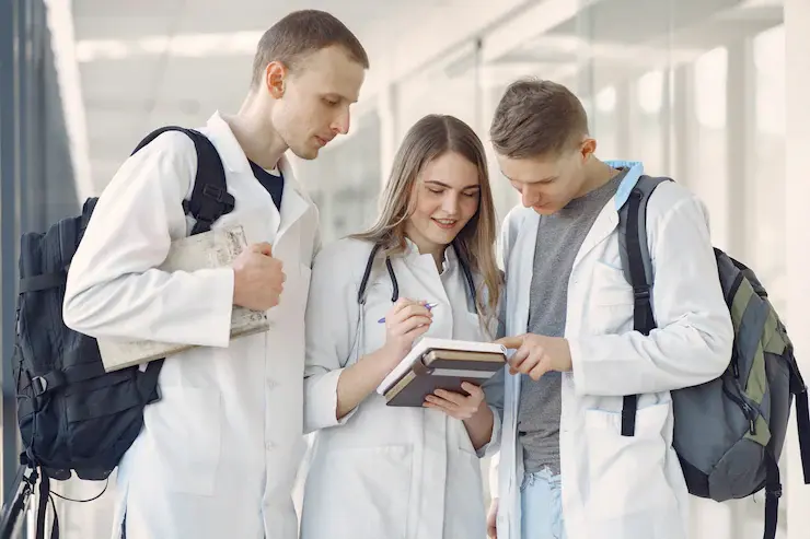 Students reviewing medical and healthcare course options on a laptop with medical symbols in background